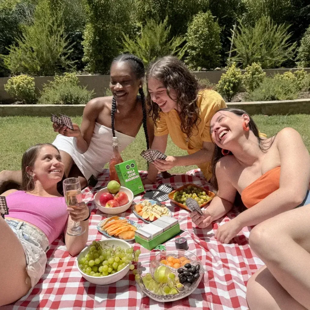grupo de mujeres riendo y jugando mala leche de marihuana en picnic