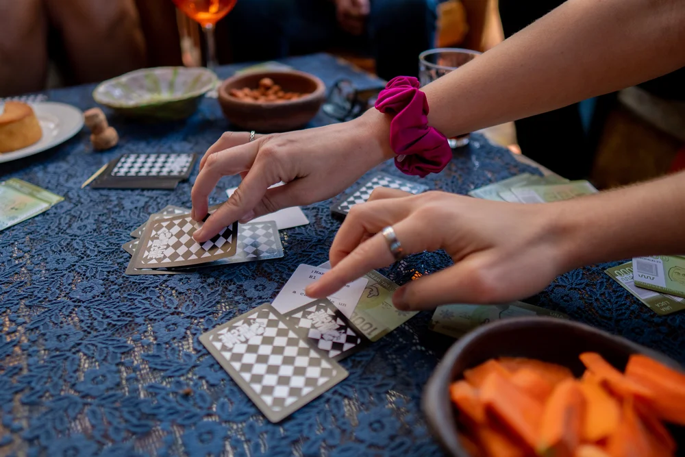 juego mala leche manos tomando cartas de mala leche de marihuana sobre mesa en junta jardin