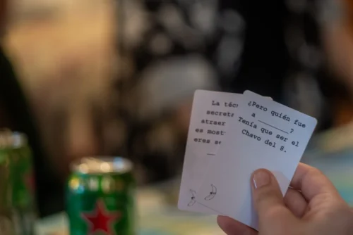 mano sosteniendo cartas blancas de mala leche con plátano