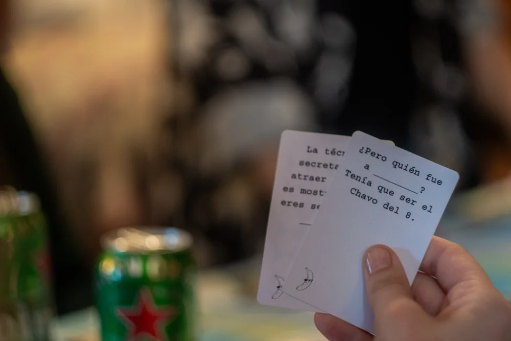 mano sosteniendo cartas blancas de mala leche con plátano